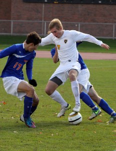 Ryan Tollefsrud fights to maintain possession against a pair of Scot defenders. Photo courtesy of Laura Westphal - Sport PiX. 