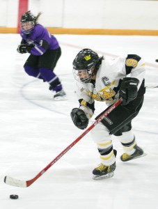 Melissa Mackley pushes the puck up the ice.