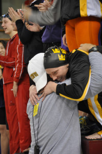 Senior Katie Olson gets a hug from head coach Jon Carlson after claiming her second straight title in the 100 free. 