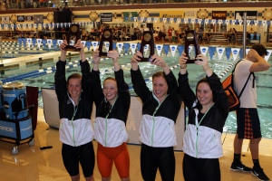 The 200-medley relay holds up its seventh place trophies. 