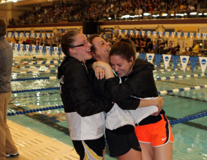 Jenny Strom, Dani Klunk, and Hayley Booher hug after the meet. 